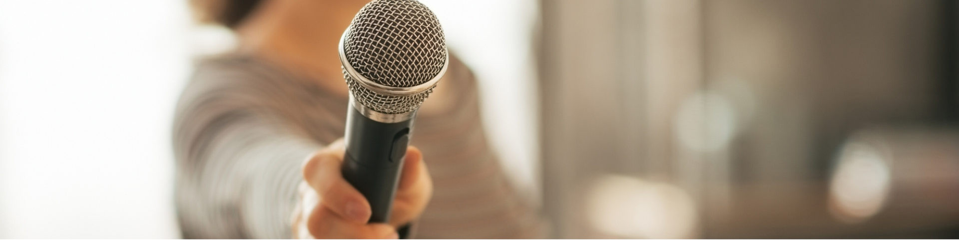 A close up of a microphone being held towards the camera.