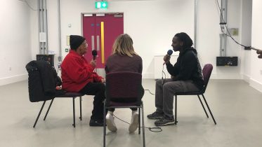 Two young people from Glow interviewing an elder from Stockwell Good Neighbours.