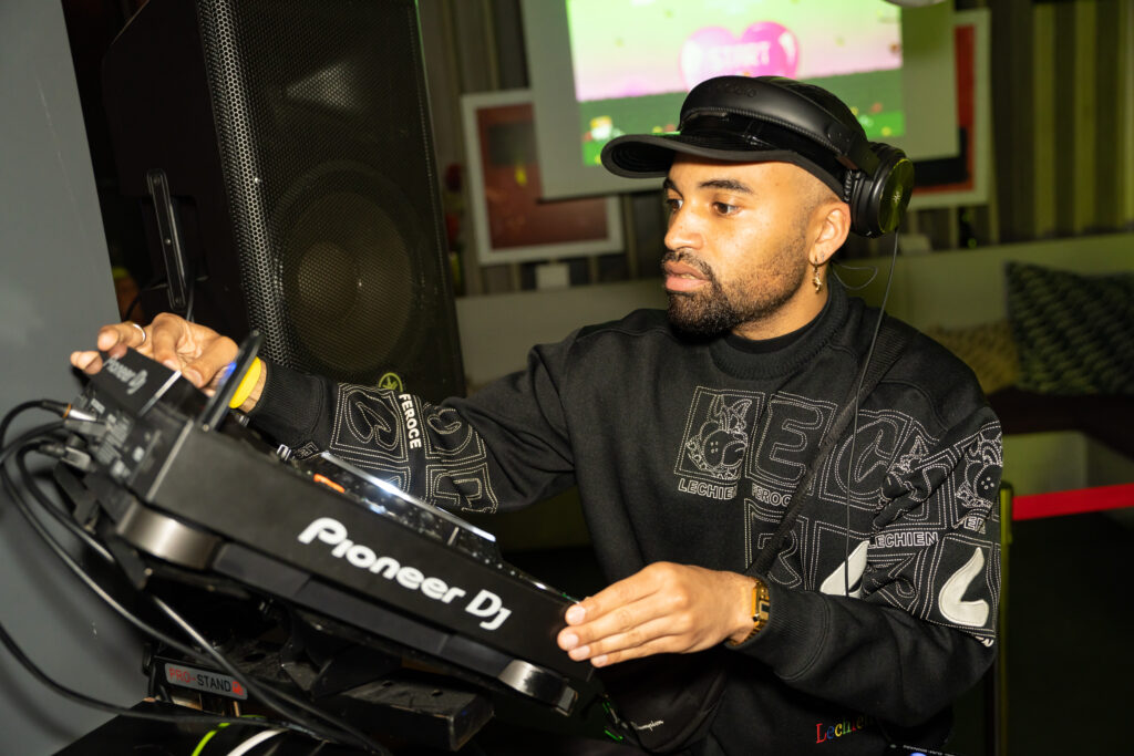 A man standing behind a DJ deck playing music