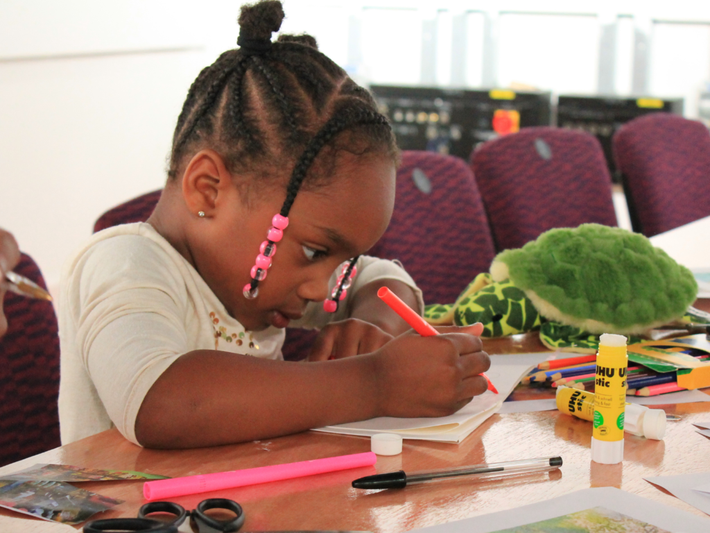 A little girl colouring in at Brixton House