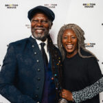 New Chair Designate Levi Roots, smiling with Delia Barker at Brixton House in front of a Brixton House step and repeat banner